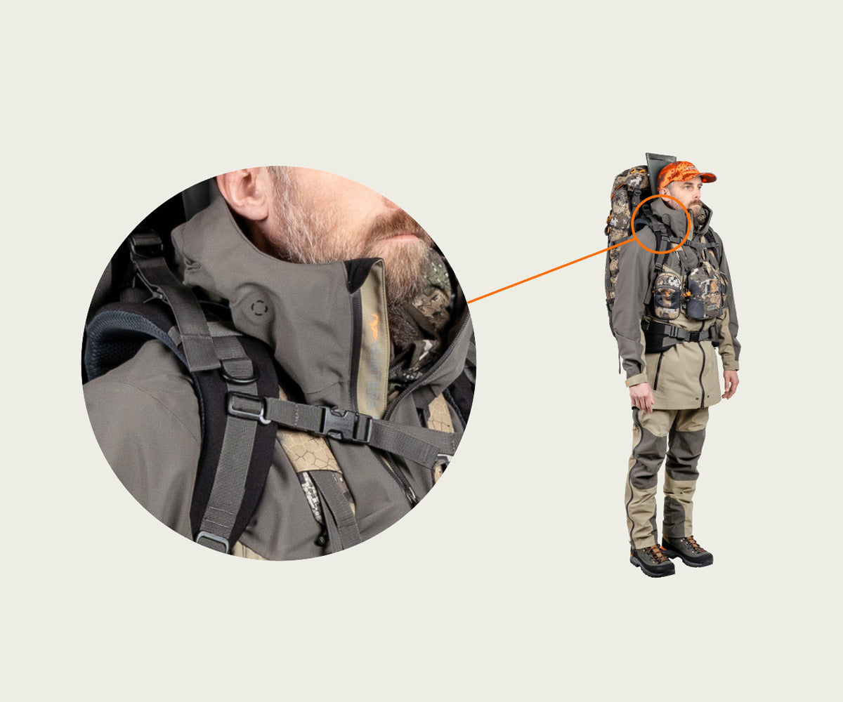 Person wearing a hunting outfit with a backpack on a beige background