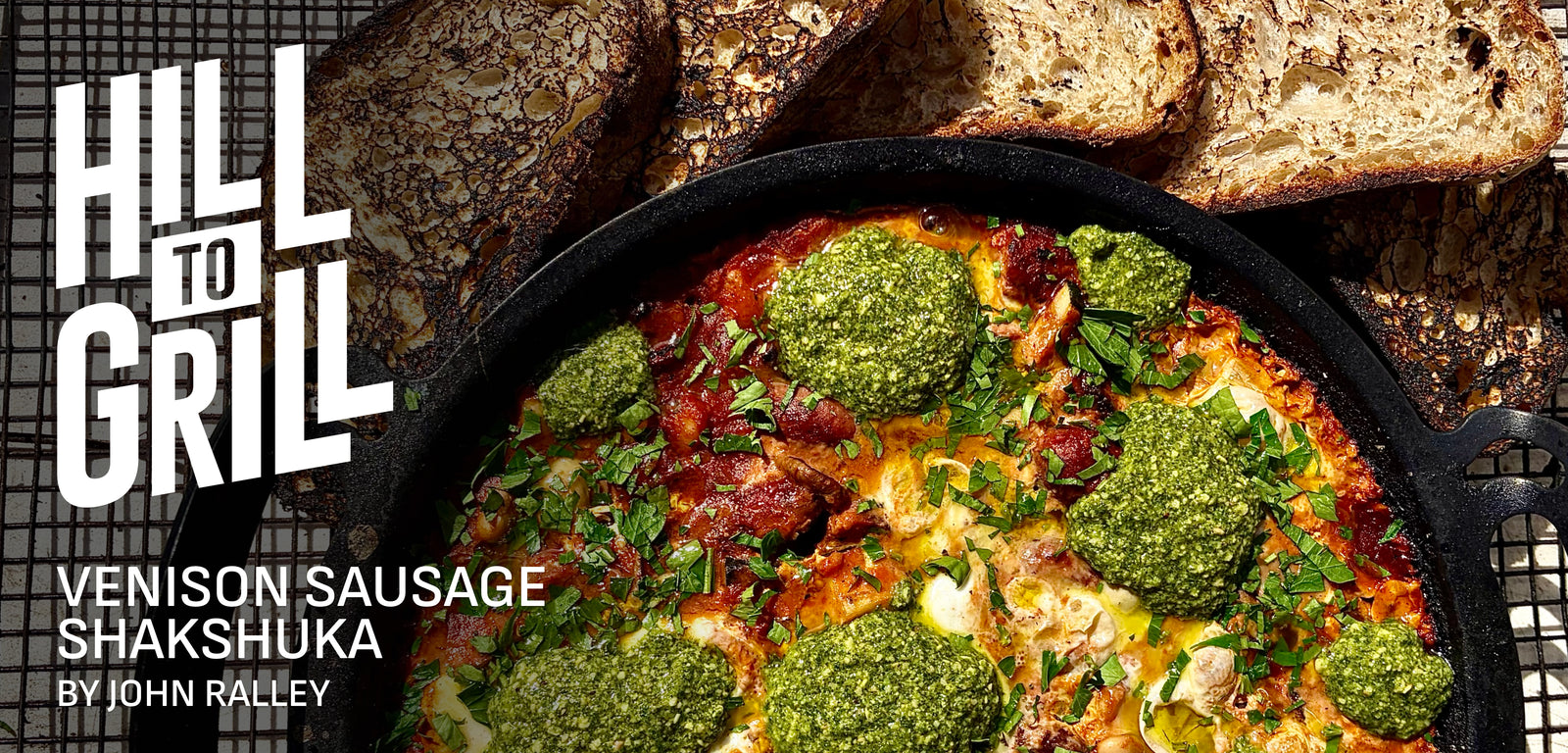 Venison sausage shakshuka with green herbs in a skillet, surrounded by bread, on a rustic background with 'Hill to Grill' branding.