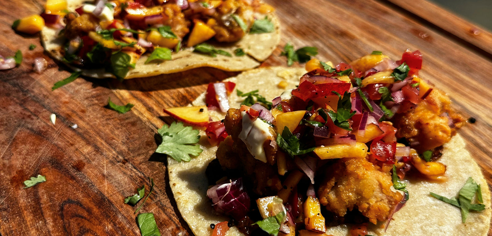 Tacos with colorful toppings on a wooden surface